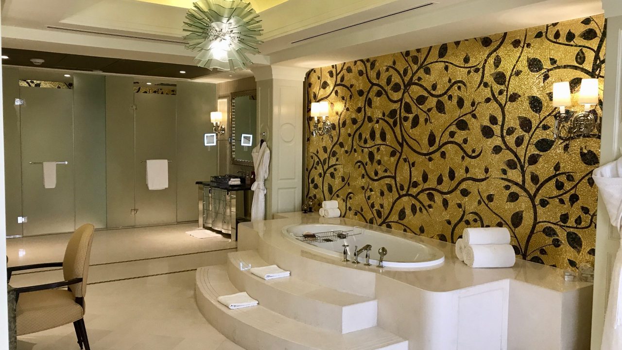 Luxushotel The Ritz-Carlton Abu Dhabi großzügiges Badezimmer in der Royal Suite. Goldene Wand, riesige Badewanne, Lampen und größter Luxus.
