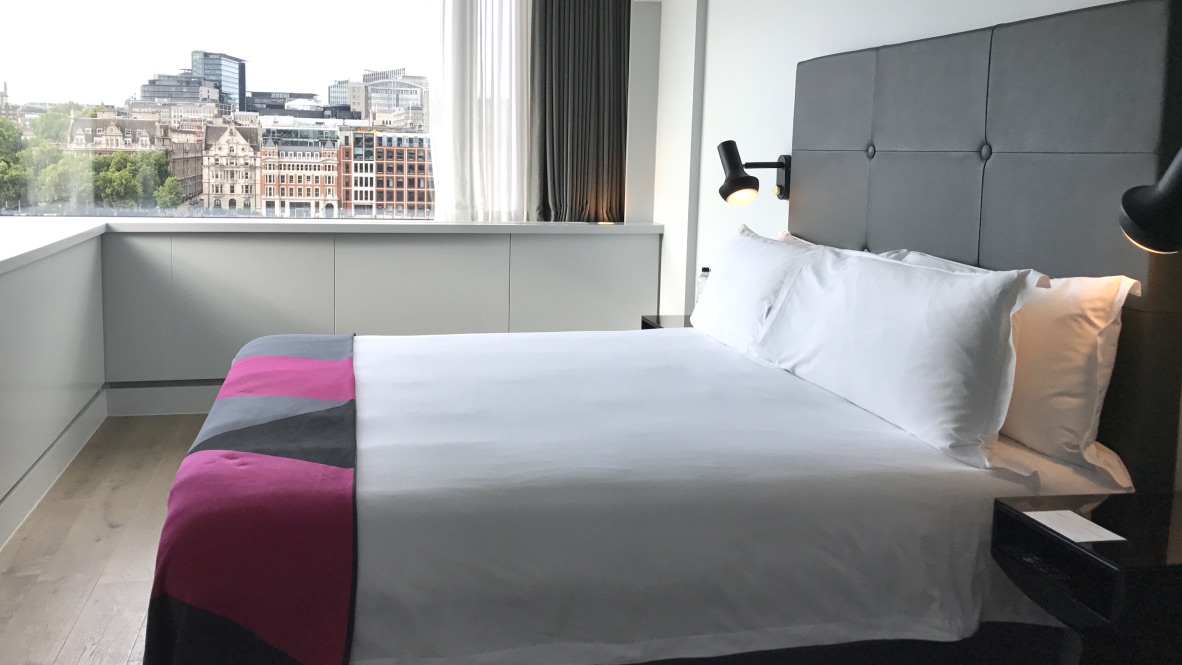 Hotel Mondrian River View Balcony Suite. Vom großen Design Bett aus siehst du durch das Panoramafenster auf die Themse und die Stadt.