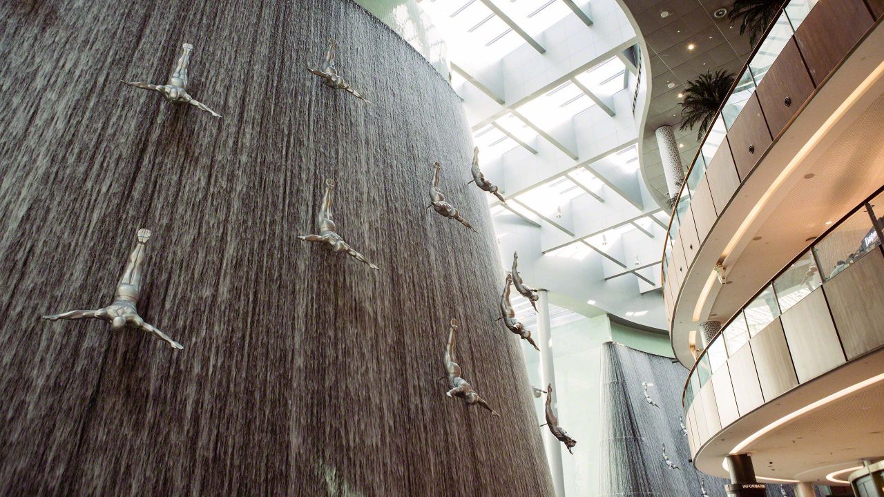 Kunstvoll in die Dubai Mall integrierter gigantischer Wasserfall mit Skulpturen
