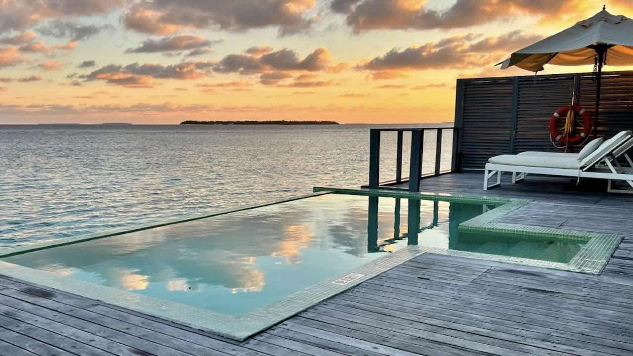 Noku Maldives Malediven Reisetipps Water Villa mit Pool im Sonnenuntergang